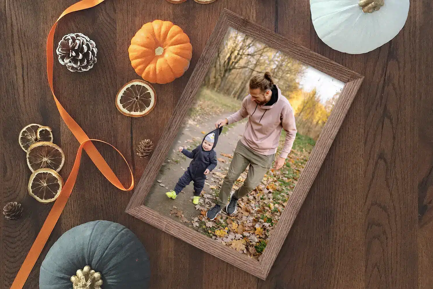 Tafel met herfstversiering en een fotolijst met daarin een foto van een klein kindje en zijn vader.