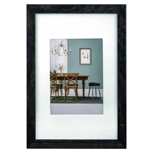 Zwart houten fotolijst met afbeelding van modern eetkamerinterieur, blauwe wand en hangende kroonluchter.