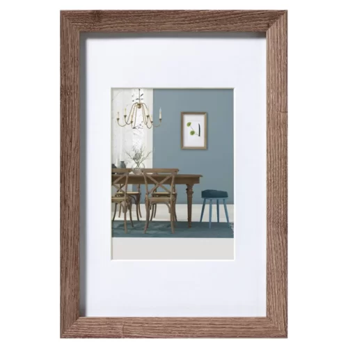 Notenbruine houten fotolijst met afbeelding van modern eetkamerinterieur, blauwe wand en hangende kroonluchter.
