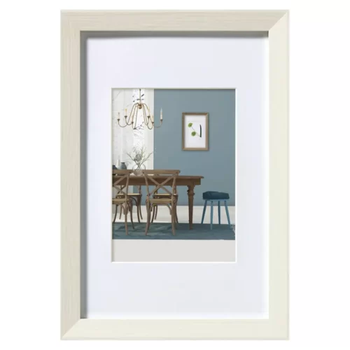 Wit houten fotolijst met afbeelding van modern eetkamerinterieur, blauwe wand en hangende kroonluchter.